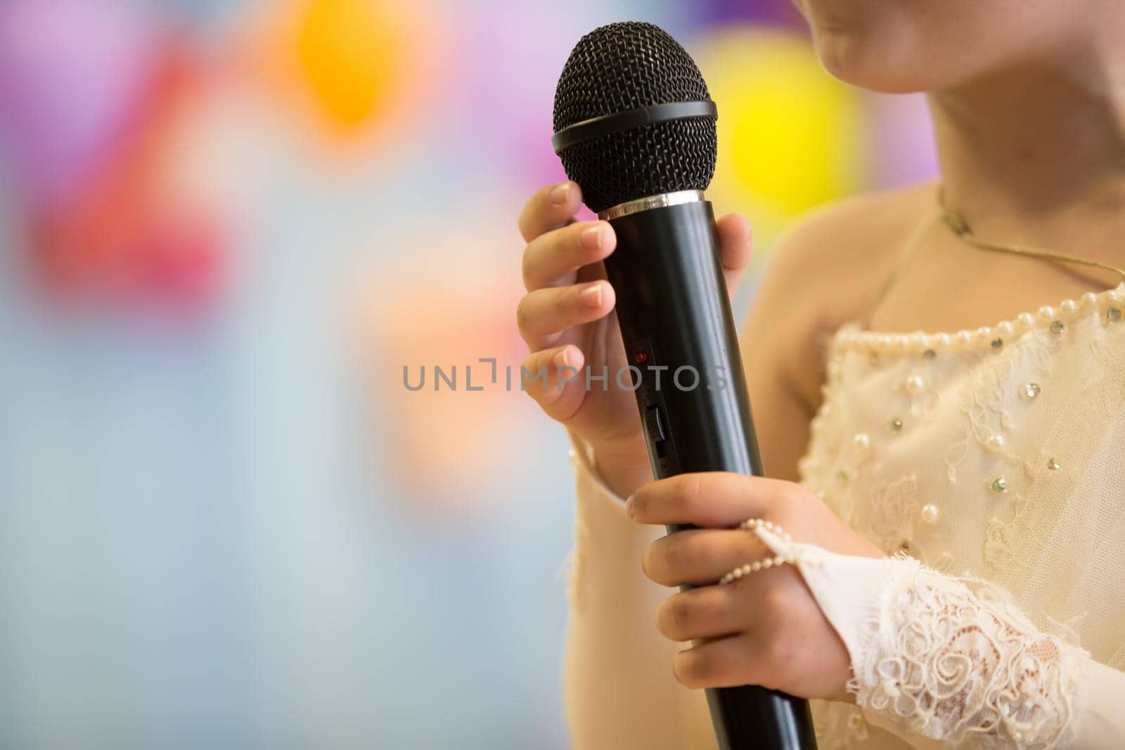 Children's hands hold a microphone