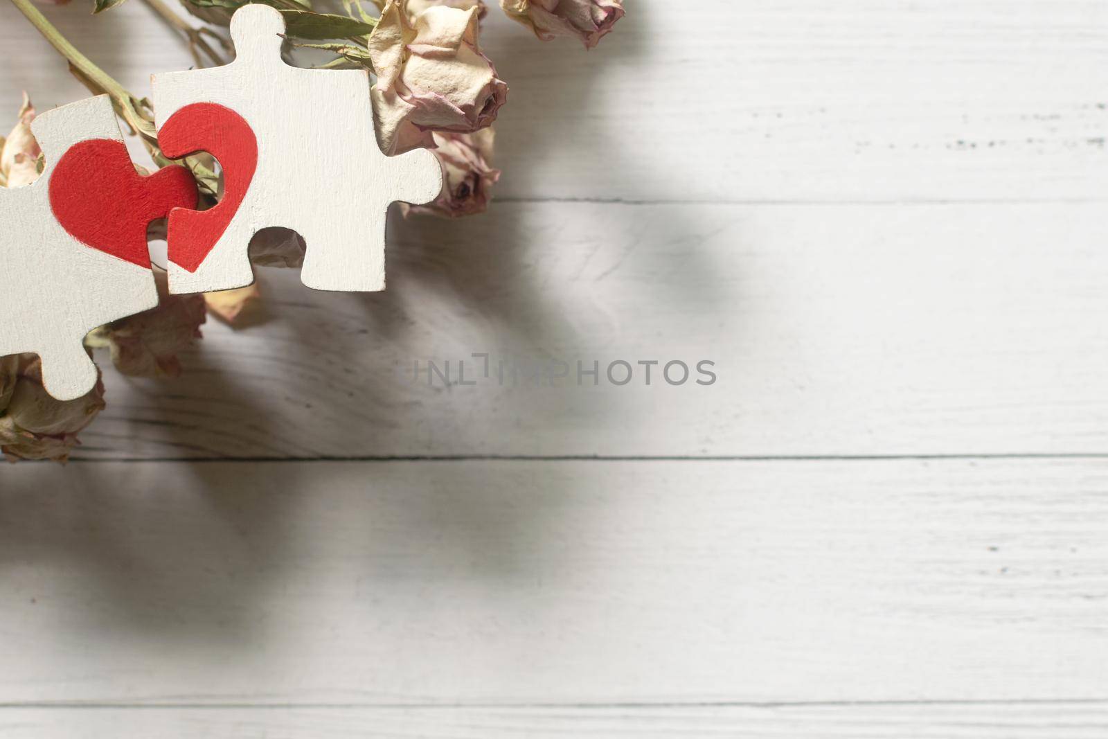 Red heart is drawn on the pieces of the puzzle lying next to each other on white background. Love concept. Divorce