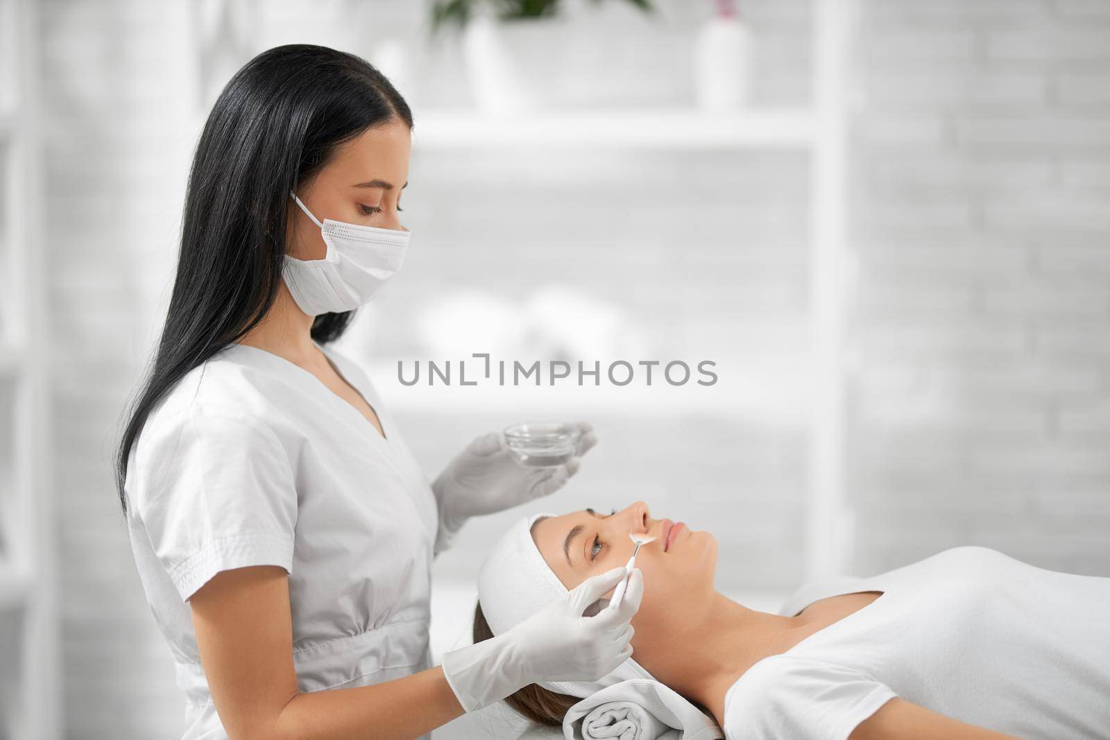 Young woman doing special procedure for improvements skin. by SerhiiBobyk