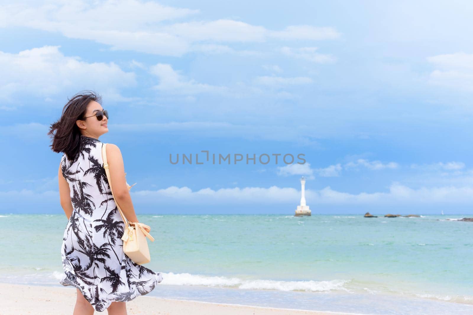 Beautiful nature landscape of the beach and sea in summer sky and cheerful woman tourist wearing sunglasse smiling with happiness on Tarutao island National Park, Satun, Thailand