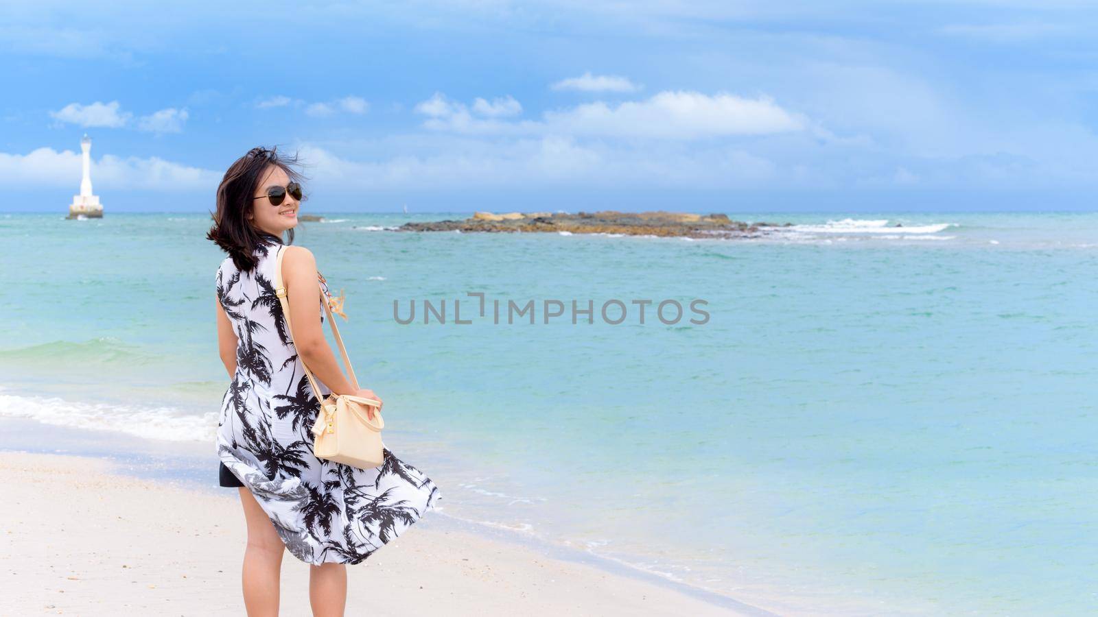 Beautiful nature landscape of the beach and sea in summer sky and cheerful woman tourist wearing sunglasse smiling with happiness on Tarutao island, Satun, Thailand, 16:9