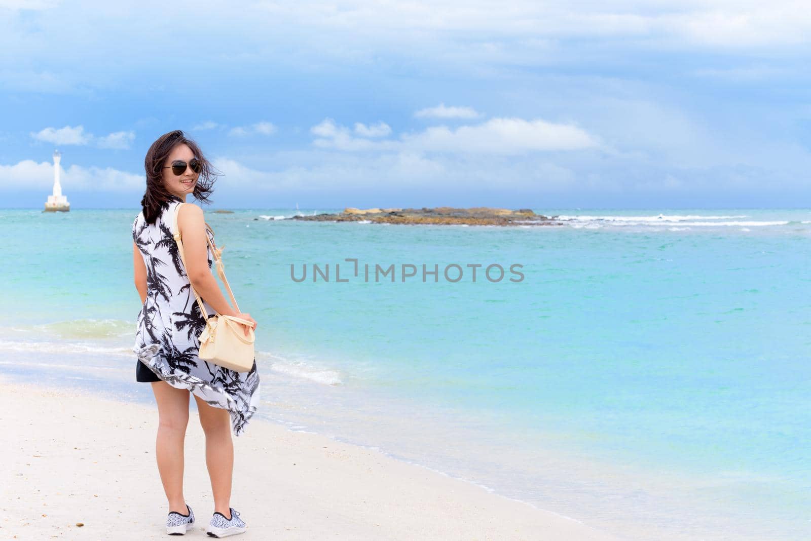 Beautiful natural landscape of the beach and the sea in summer sky and cheerful woman tourist wearing sunglasse smiling on Tarutao island National Park, Satun, Thailand