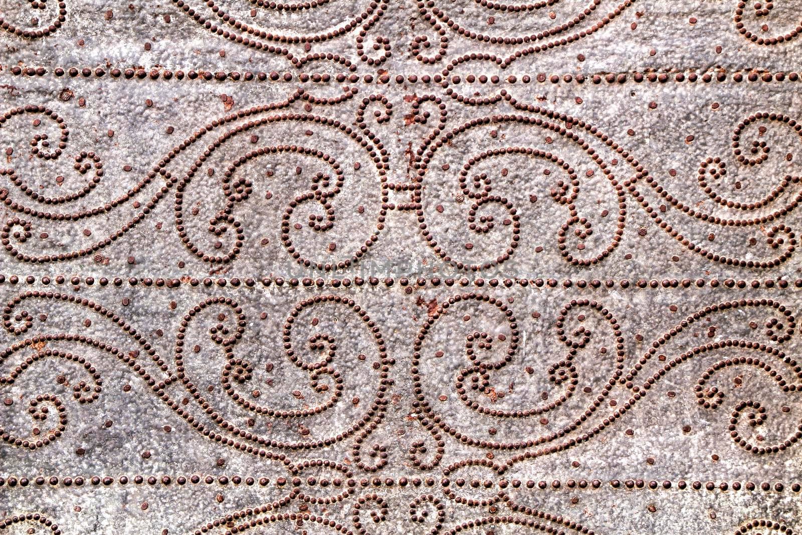 Old gray metal door of a church with wrought iron details in Murcia, Spain