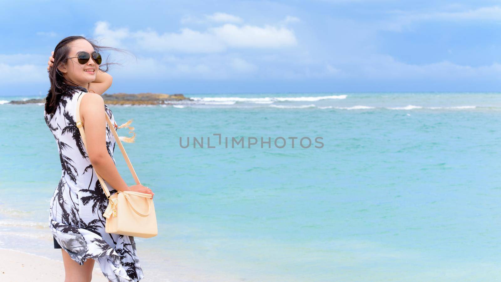 Beautiful nature landscape of the beach and sea in summer sky and woman tourist wearing sunglasse smiling with happiness on Tarutao island, Satun, Thailand, 16:9 widescreen