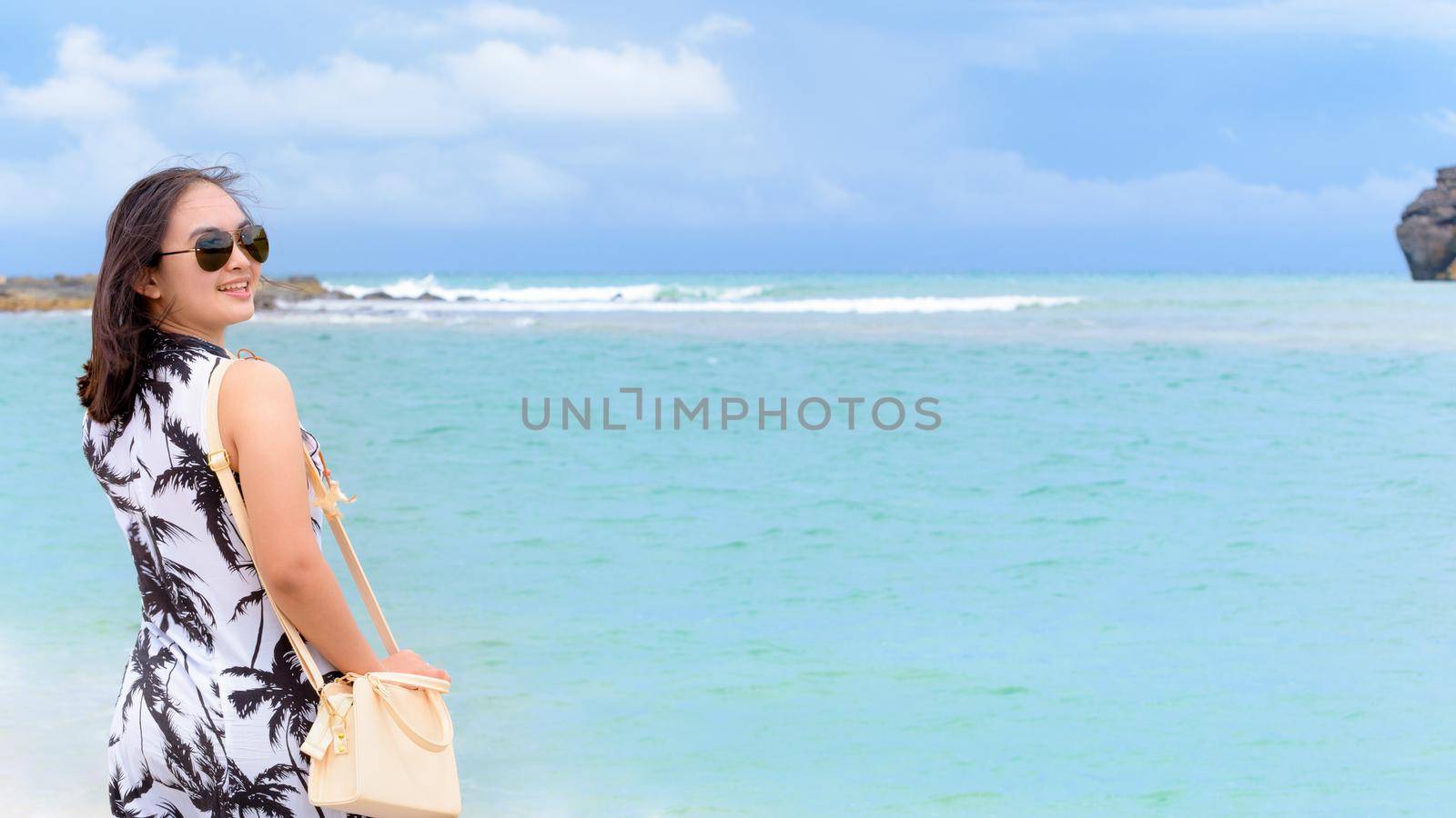 Beautiful nature landscape of the beach and sea in summer sky and woman tourist wearing sunglasse smiling with happiness on Tarutao island, Satun, Thailand, 16:9 widescreen