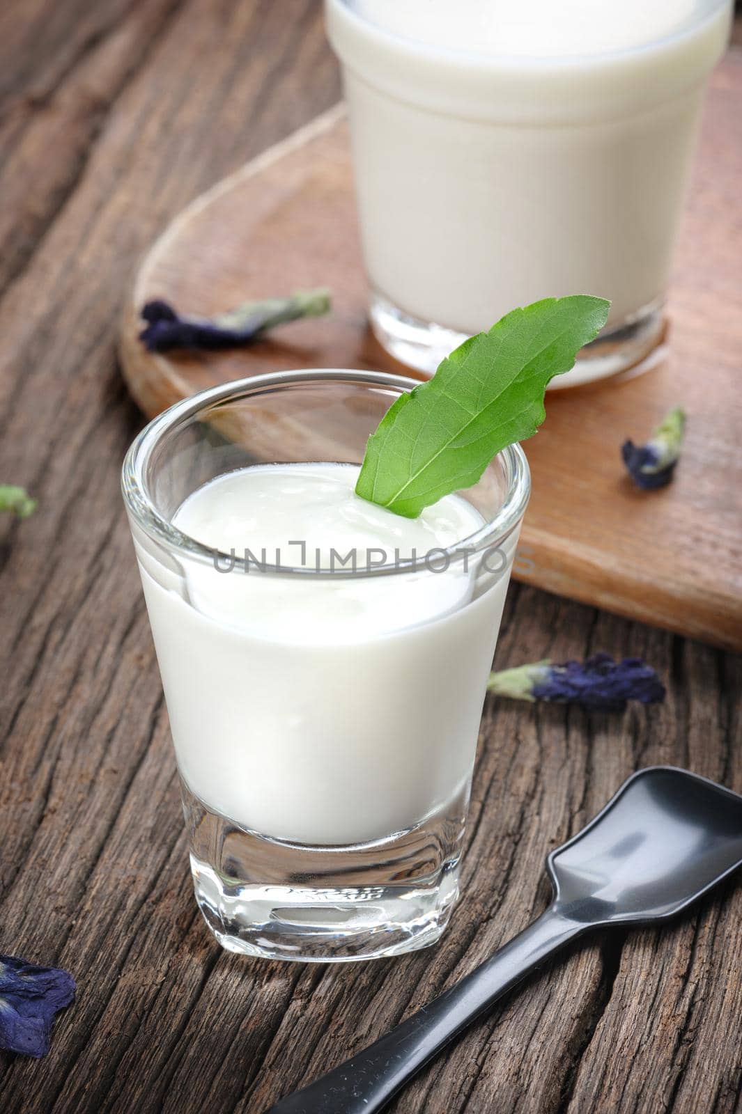 fresh natural yogurt in glass on wooden plank