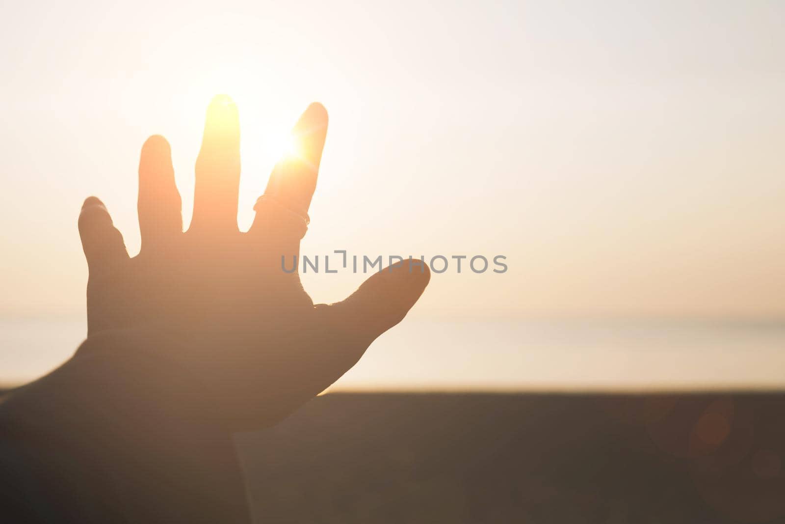 Hand reach out to sunset sky beach sand nature background. Relax and rest in vacation time
