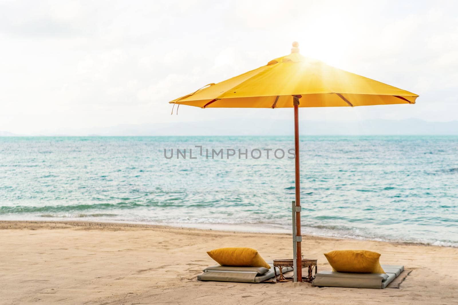 Umbrella and chair at tropical summer beach background with copy space blue sky