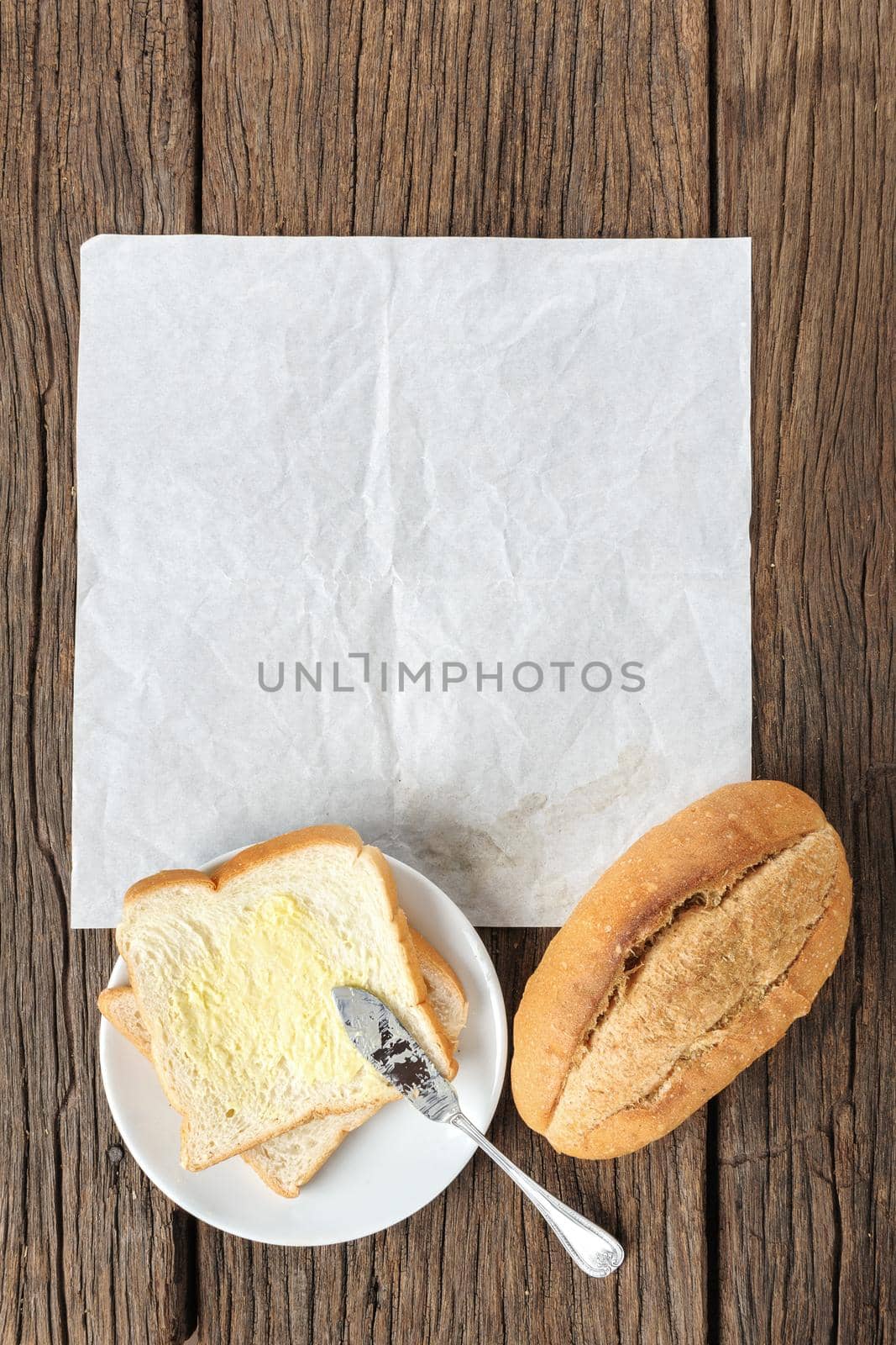 blank white folded paper on wooden desk with bread