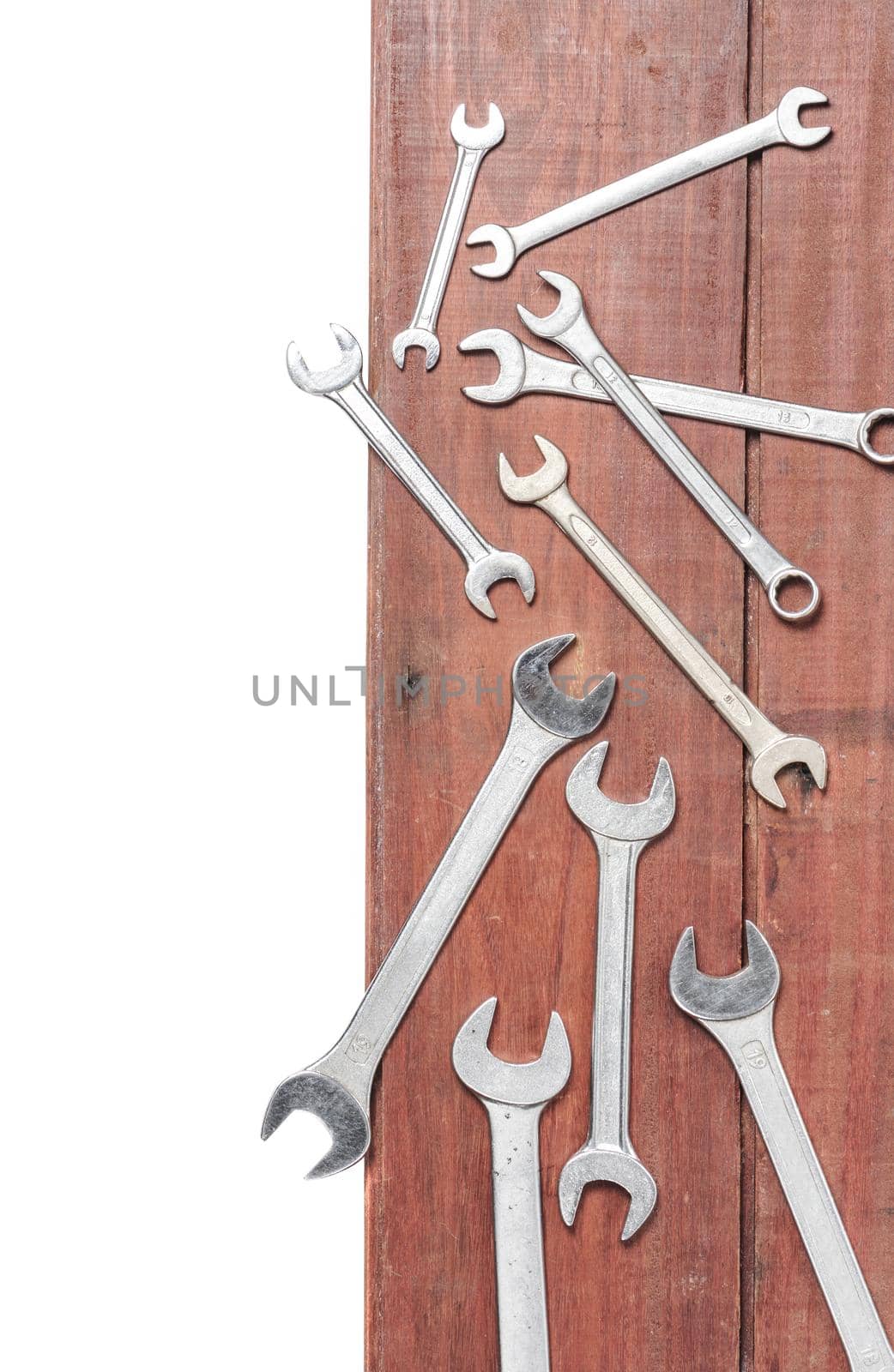 wrenches on wooden plank background