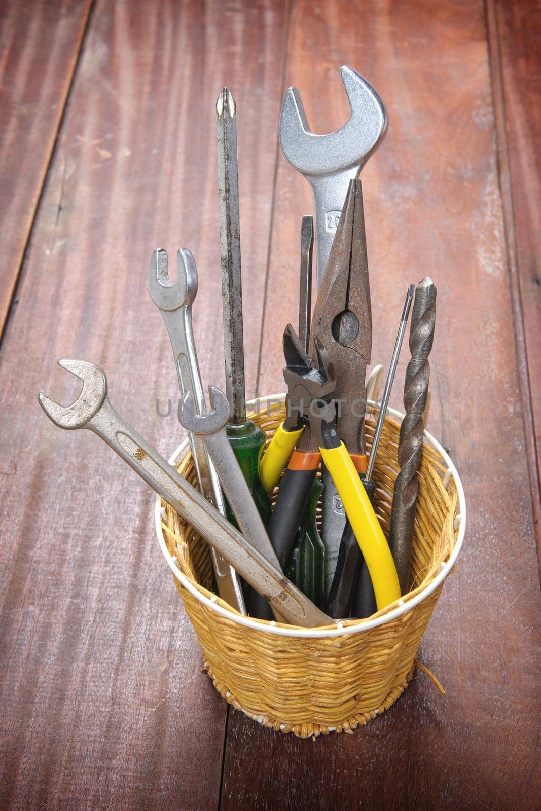 many tools in the basket on wooden plank