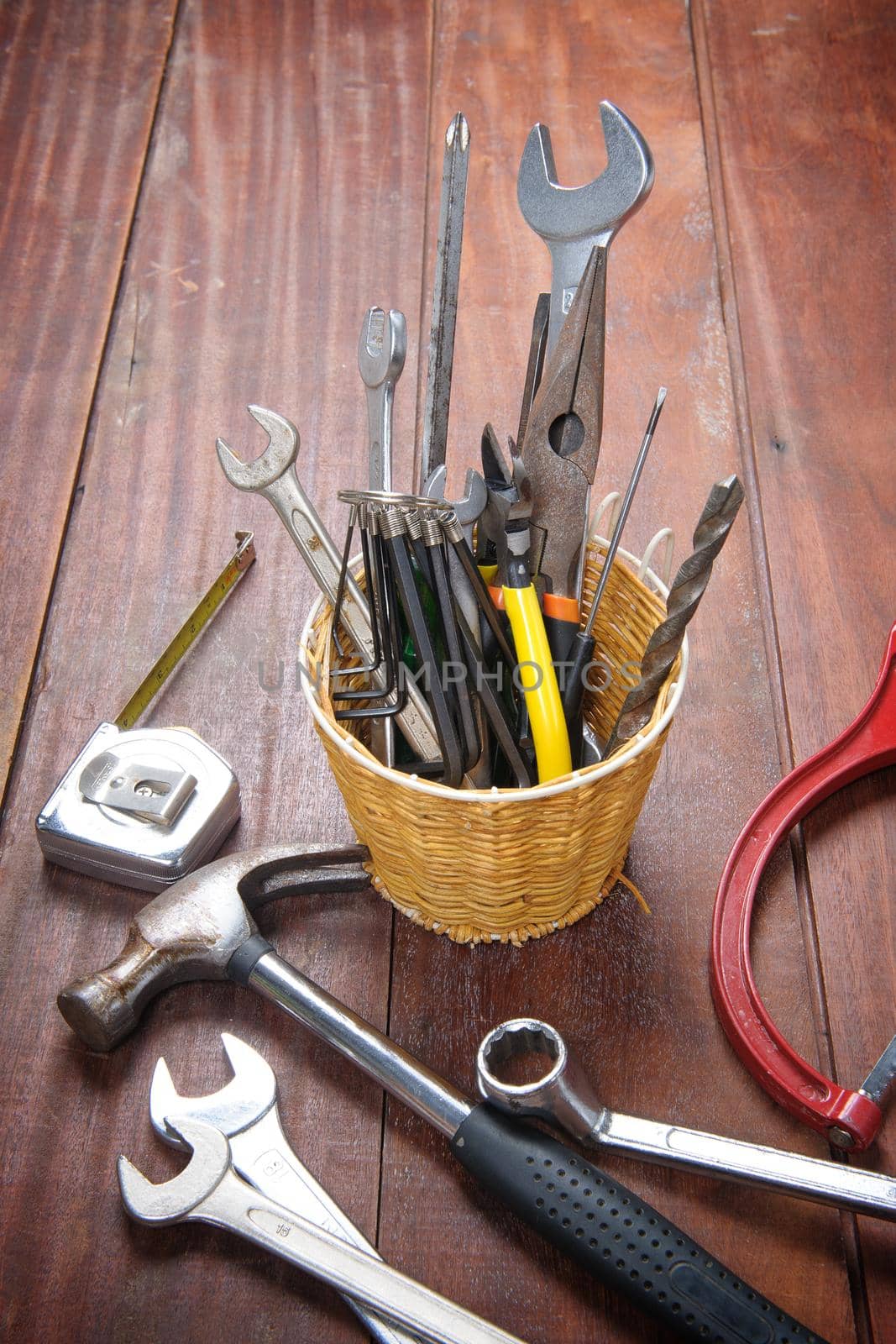 many tools in the basket on wooden plank