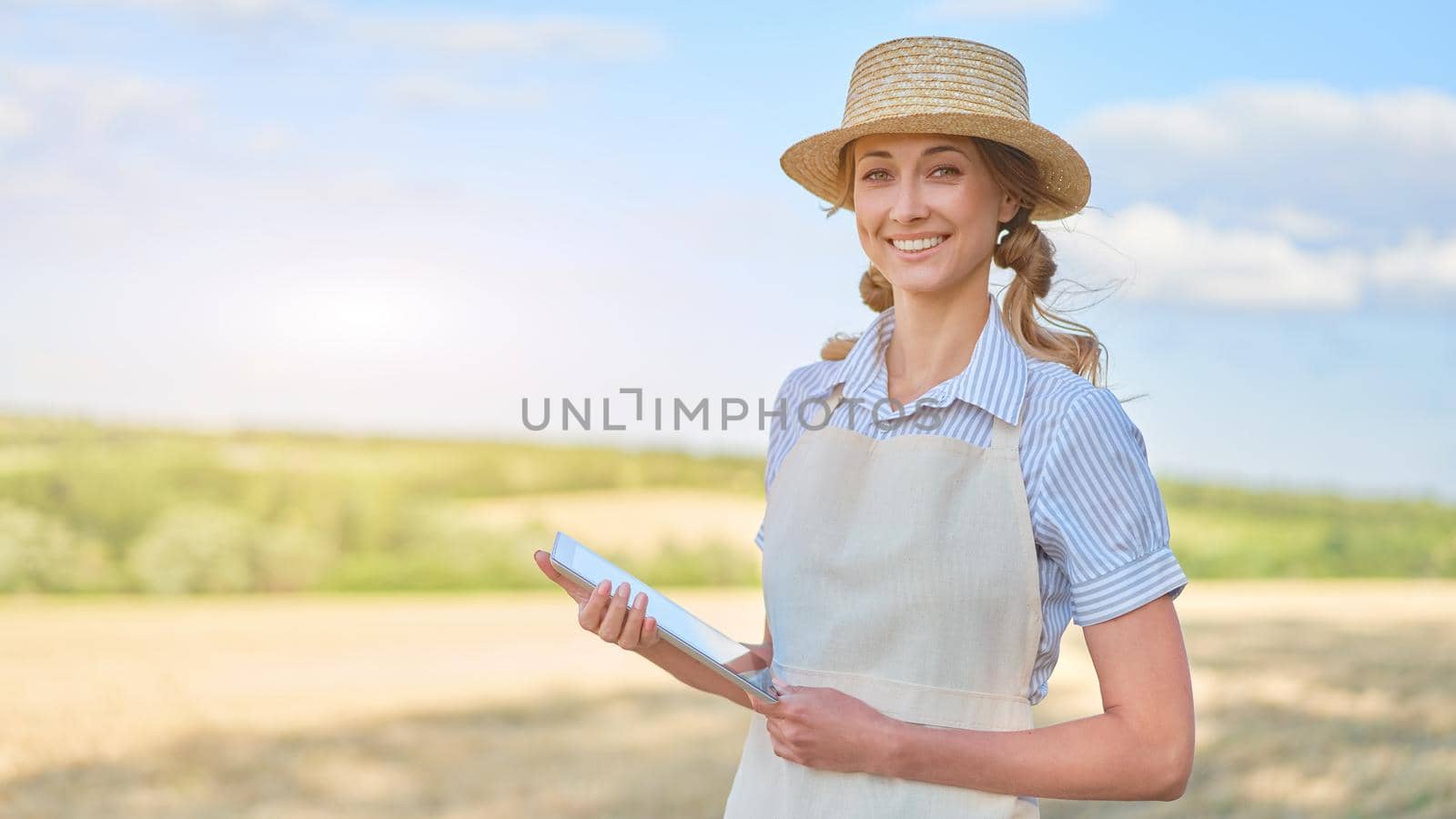 Woman farmer straw hat smart farming standing farmland smiling using digital tablet Female agronomist specialist research monitoring analysis data agribusiness Caucasian worker agricultural field