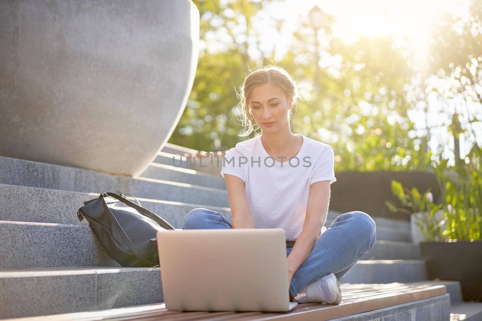 Businesswoman sitting stairs summer park using laptop Business persone working remote. Outdoor Successful european caucasian woman freelancer make video call teacher study work online lessons