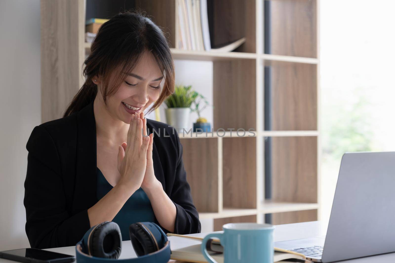 Thai business woman greeting customer while video call with laptop. by itchaznong