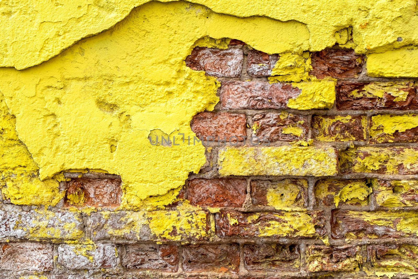 Close-up of a fragment of an old wall with bright yellow brickwork.