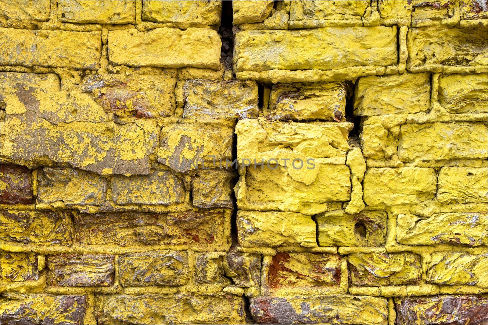 Close-up of a fragment of an old wall with bright yellow brickwork.