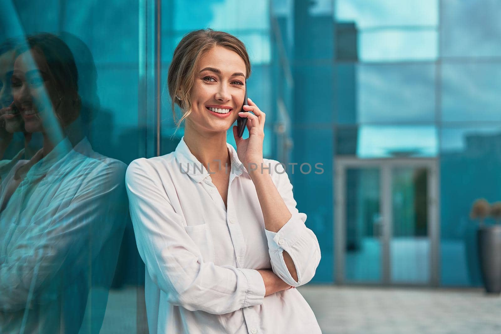 Businesswoman successful woman business person standing outdoor corporate building exterior cell phone Pensive elegance cute caucasian professional business woman middle age dreaming with mobile phone