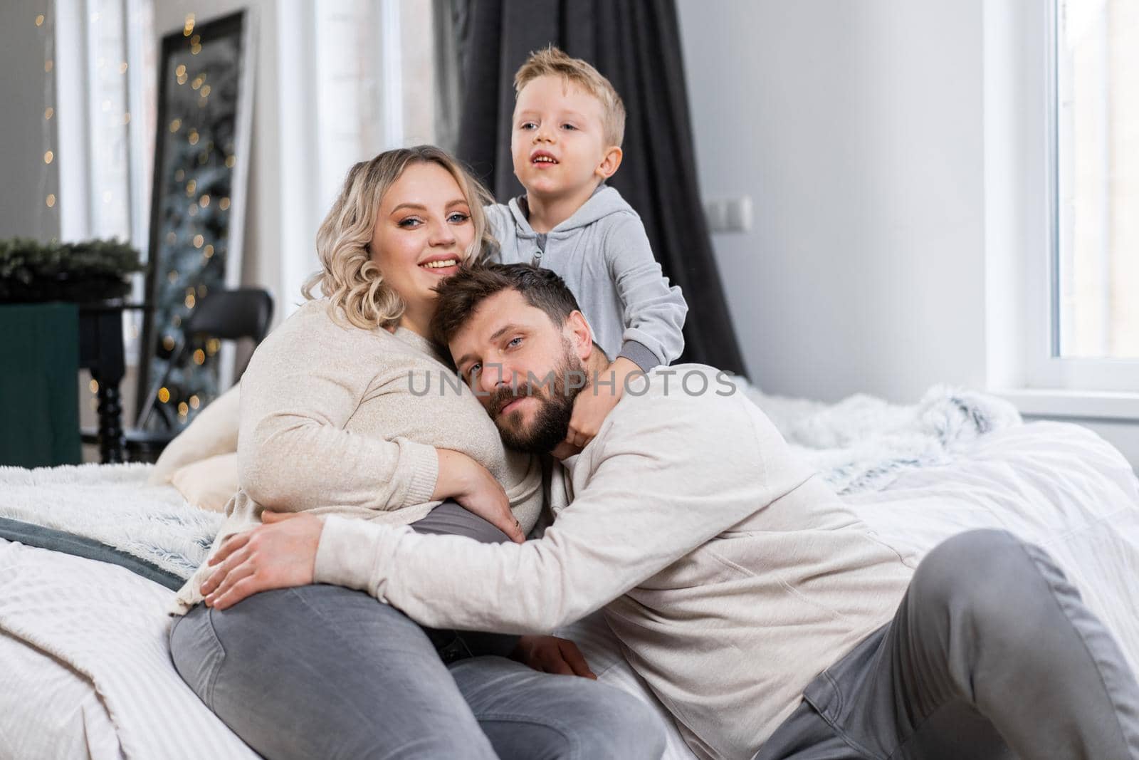 Happy family concept Mother father and little son have fun at home Caucasian family indoors Pregnant mom beard dad and funny little boy