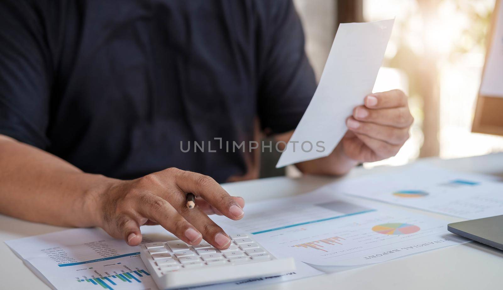 A man using calculator for calculate expenses bills in his workplace. Business concept. by wichayada