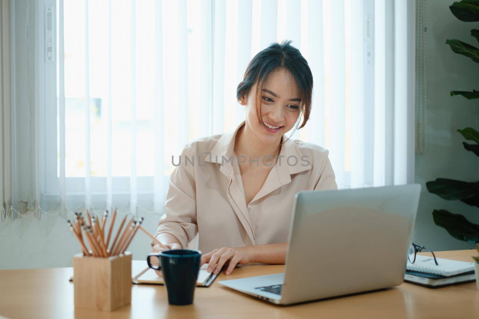 A joyful woman concentrates on a webinar on her laptop computer