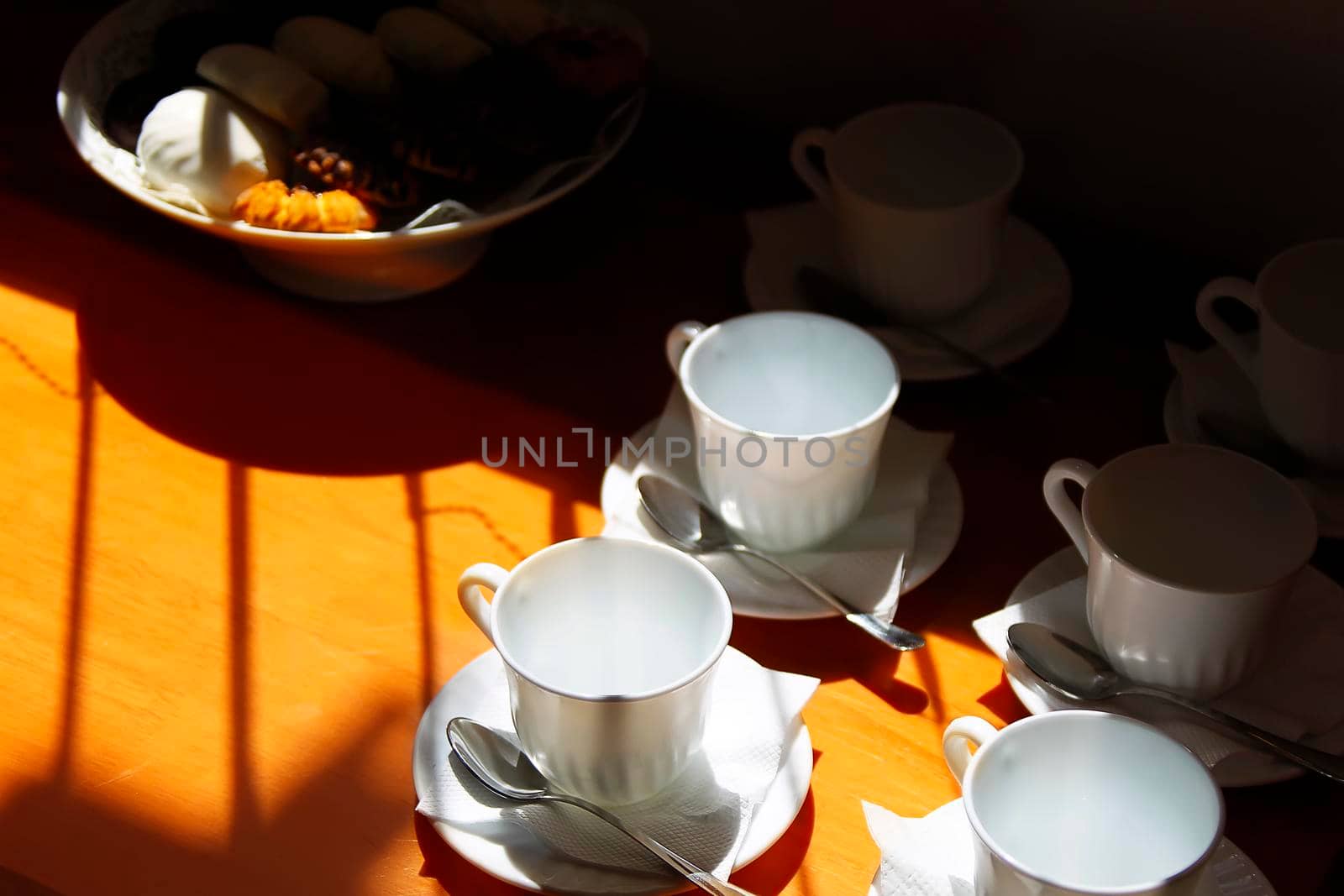 Coffee cups on the table lit by the sun