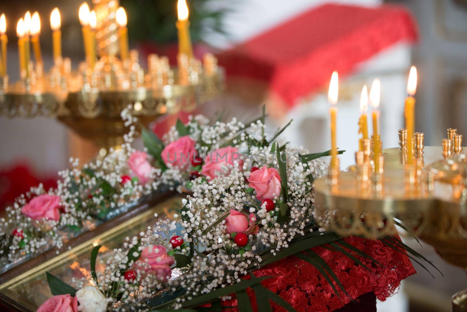 Orthodox altar with candles decorated with flowers