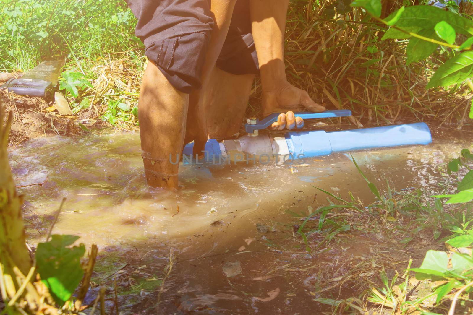 broken pipe in hole with water motion at roadside and plumber working repair