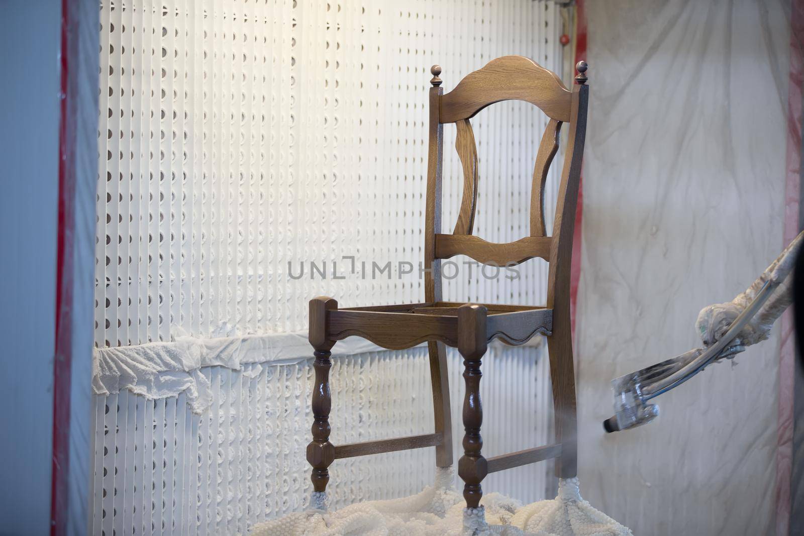 Covering the chair with lacquer.Painting chairs in the factory