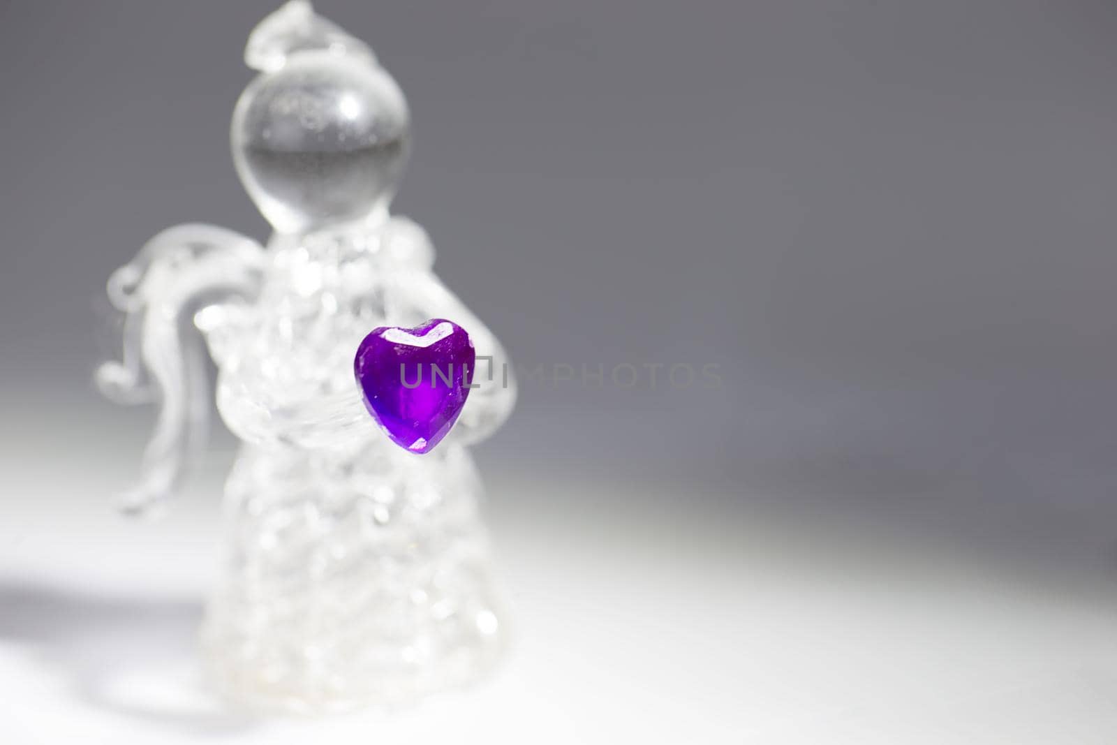 Glass angel with a purple heart closeup
