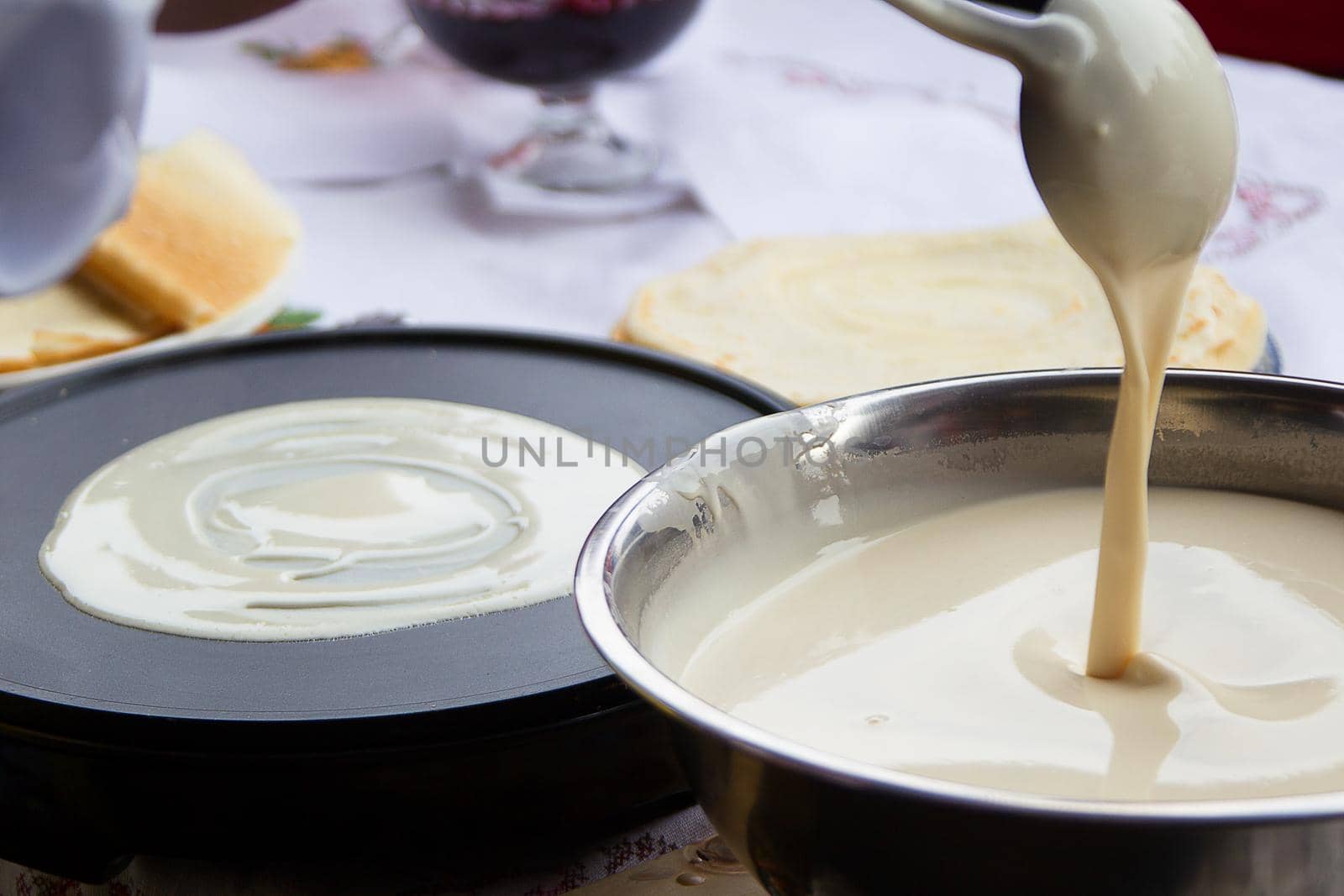 Cooking pancakes.Pour dough for pancakes into a frying pan