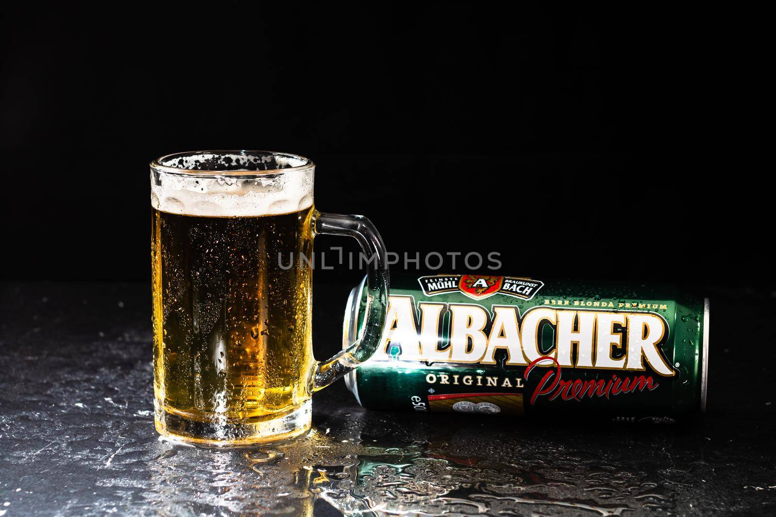 Can of Albacher beer and beer glass on dark background. Illustrative editorial photo shot in Bucharest, Romania, 2021 by vladispas