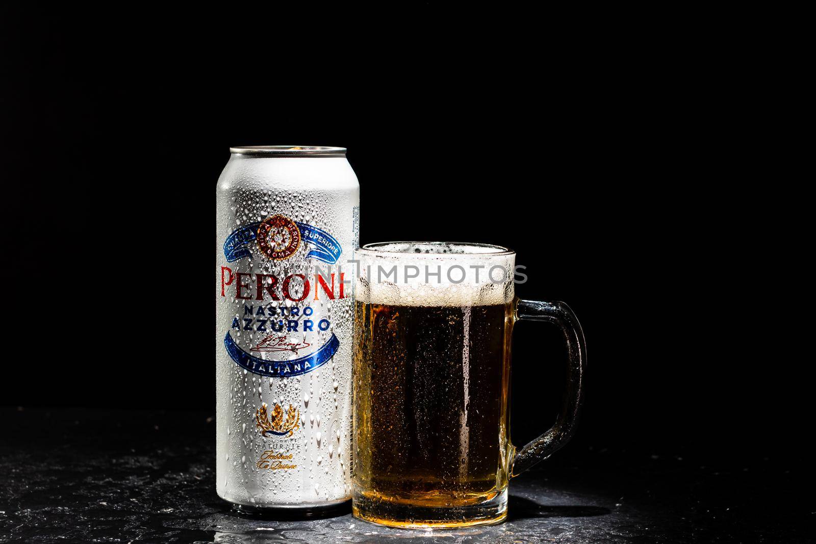 Can of Peroni Nastro Azzurro beer and beer glass on dark background. Illustrative editorial photo shot in Bucharest, Romania, 2021