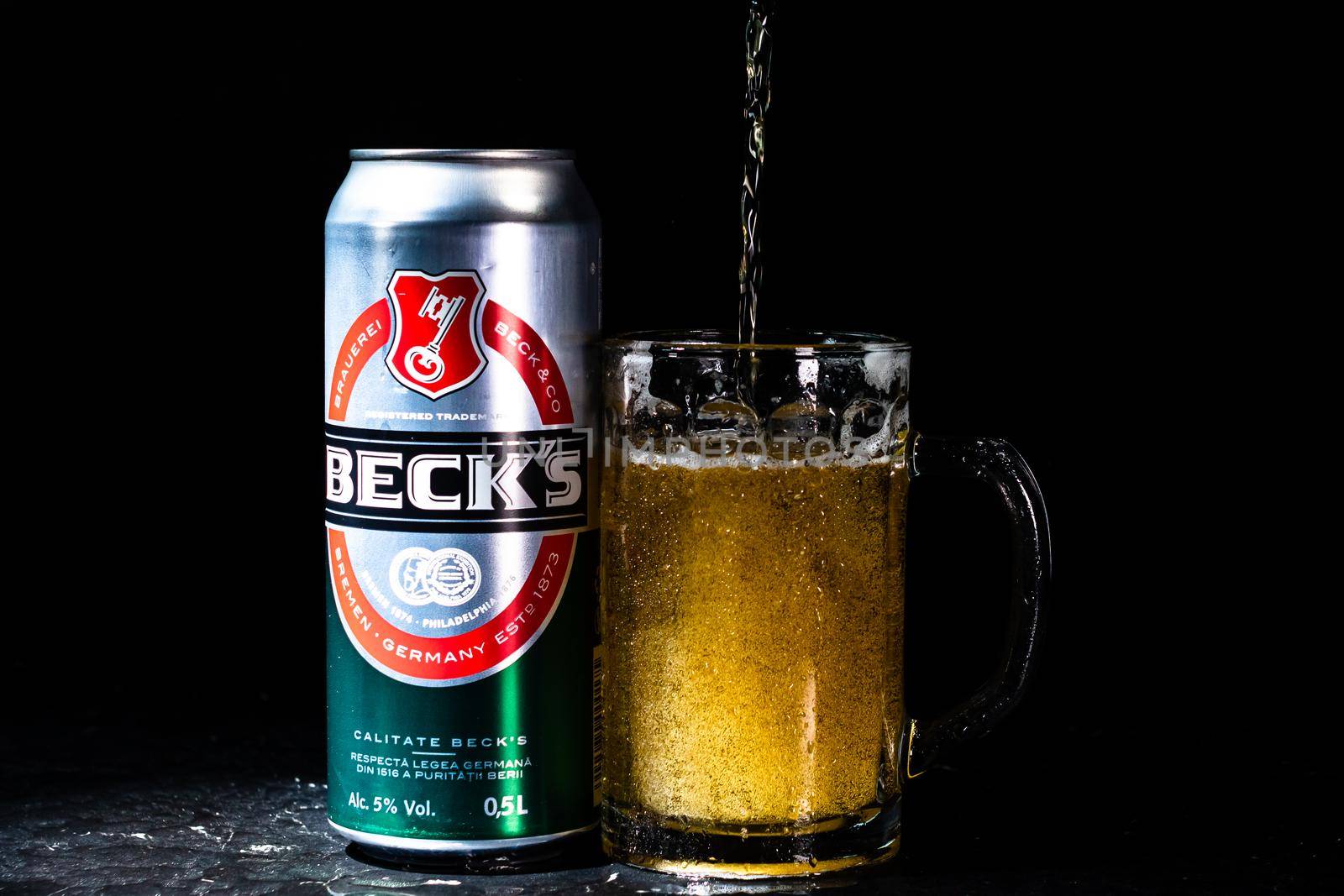 Can of Beck`s or Becks beer and beer glass on dark background. Illustrative editorial photo shot in Bucharest, Romania, 2021 by vladispas