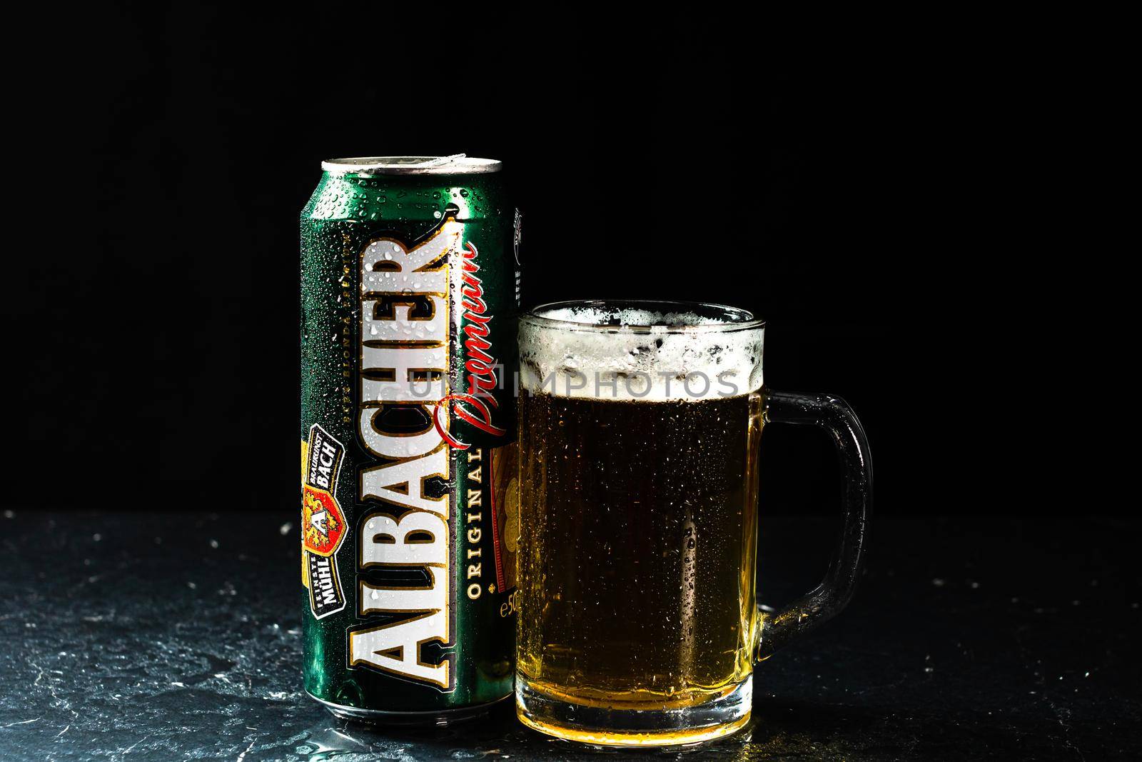 Can of Albacher beer and beer glass on dark background. Illustrative editorial photo shot in Bucharest, Romania, 2021