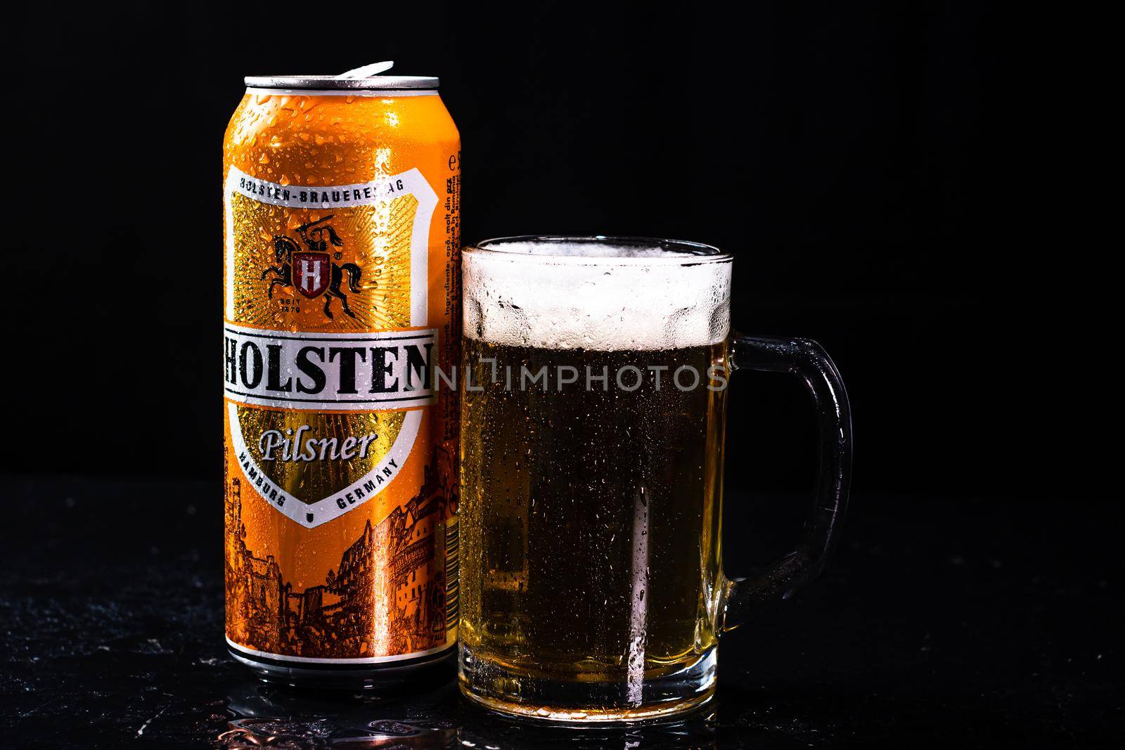 Can of Holsten beer and beer glass on dark background. Illustrative editorial photo shot in Bucharest, Romania, 2021 by vladispas