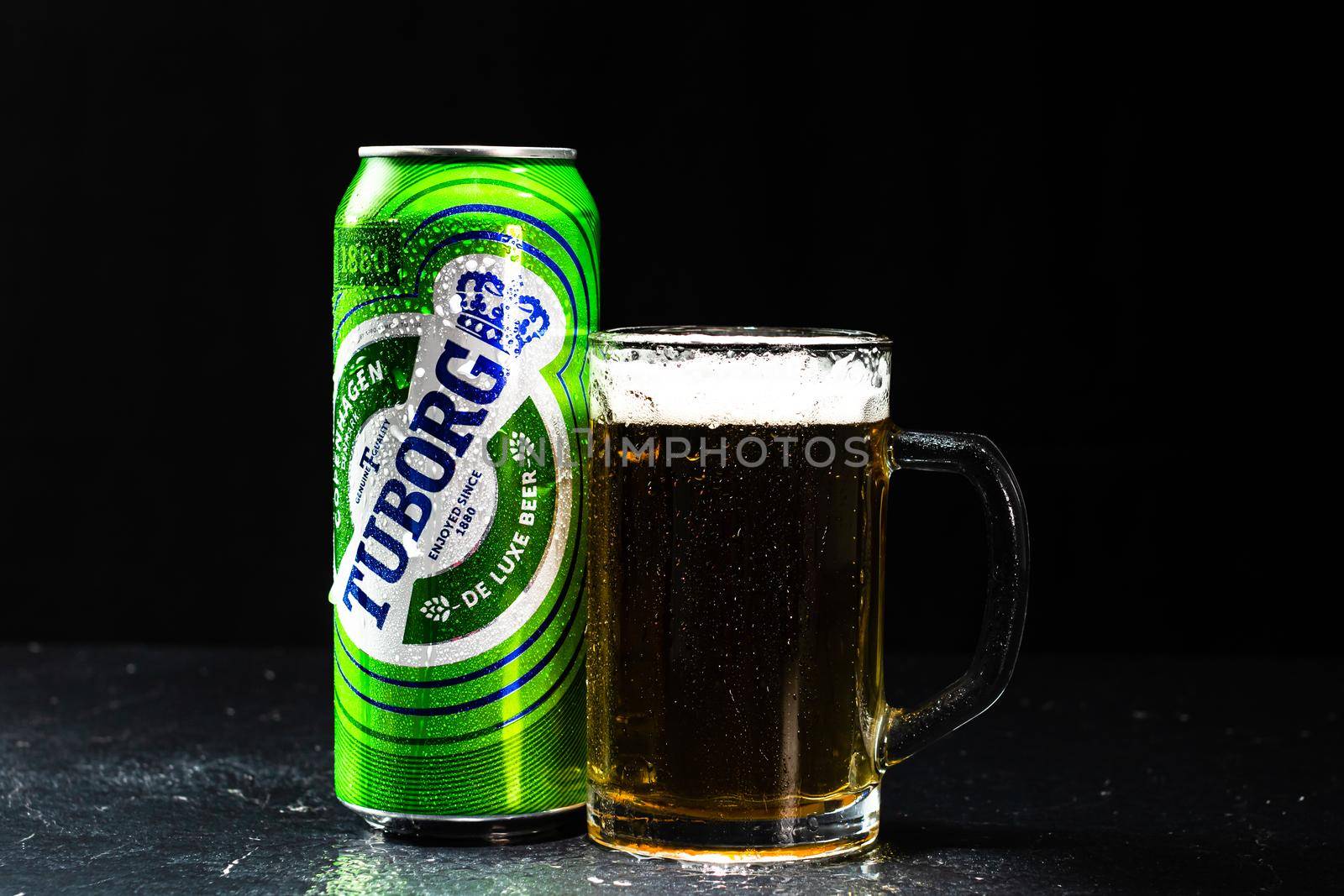Can of Tuborg beer and beer glass on dark background. Illustrative editorial photo shot in Bucharest, Romania, 2021 by vladispas