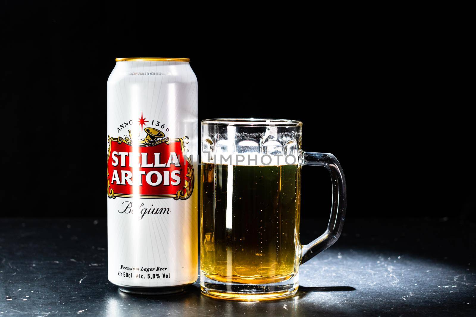 Can of Stella Artois beer and beer glass on dark background. Illustrative editorial photo shot in Bucharest, Romania, 2021