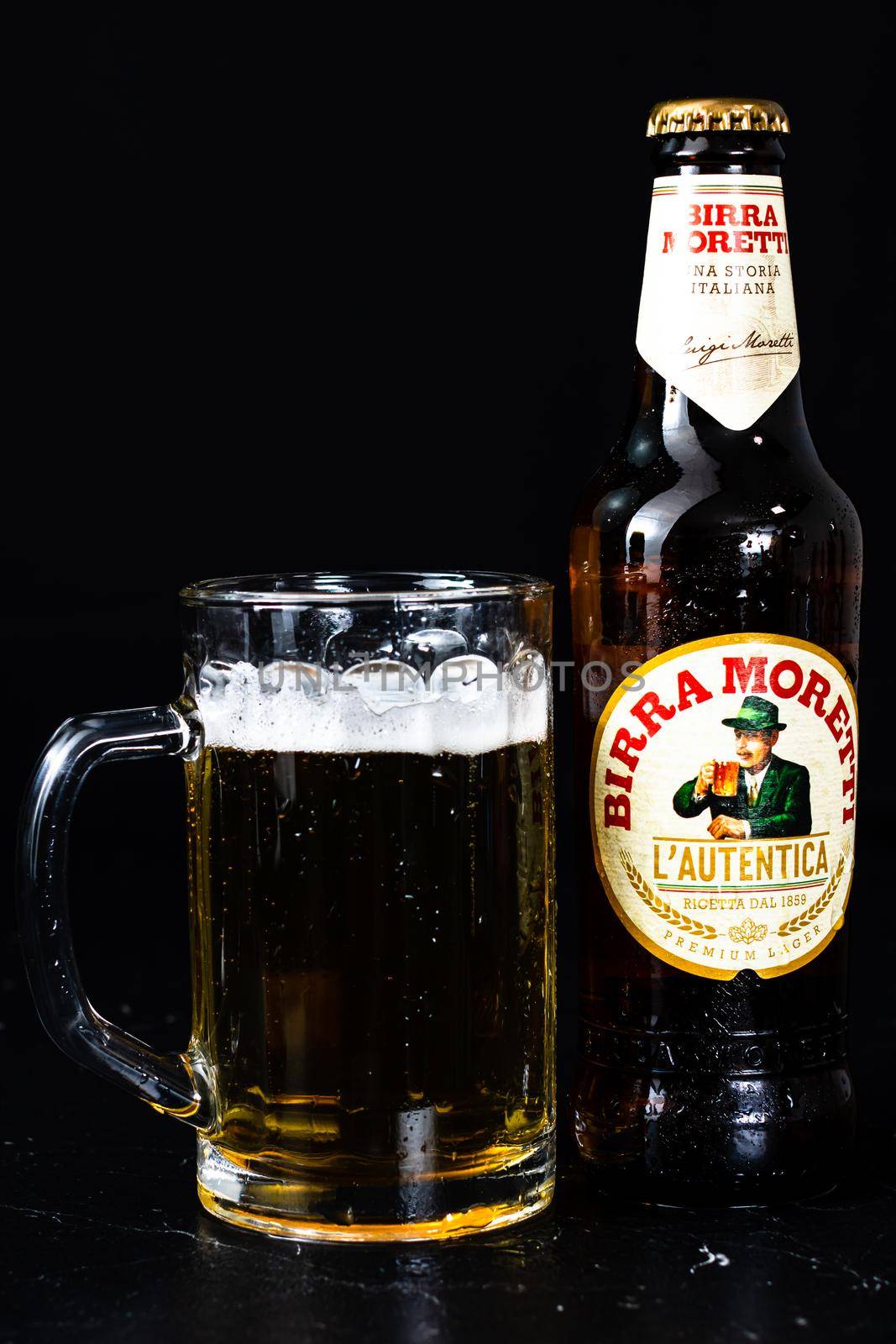 Can of Birra Morreti beer and beer glass on dark background. Illustrative editorial photo shot in Bucharest, Romania, 2021