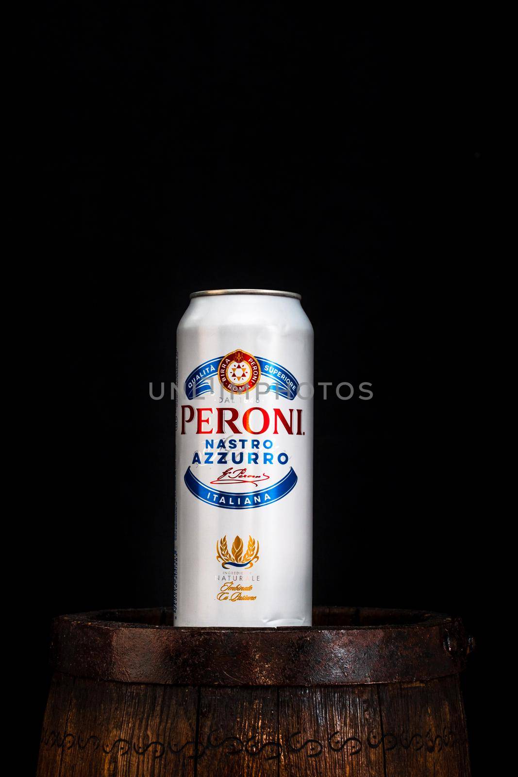 Can of Peroni beer on beer barrel with dark background. Illustrative editorial photo Bucharest, Romania, 2021 by vladispas