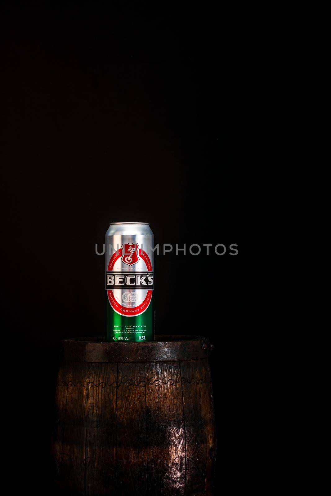 Can of Becks beer on beer barrel with dark background. Illustrative editorial photo Bucharest, Romania, 2021 by vladispas