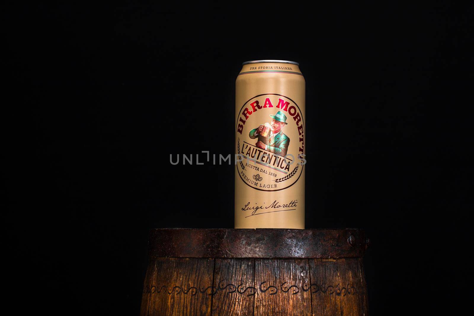 Can of Birra Moretti beer on wooden barrel with dark background. Illustrative editorial photo Bucharest, Romania, 2021