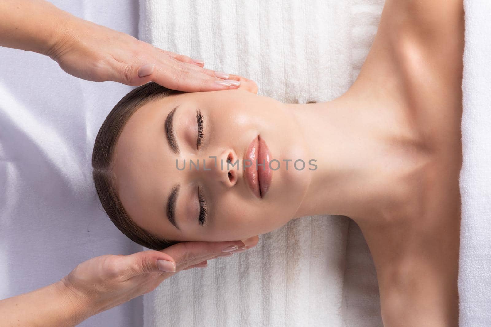 Young beautiful lady getting spa treatment face massage