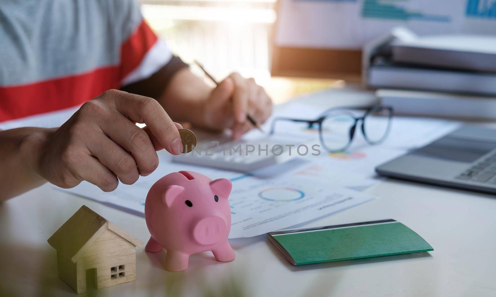 Business man putting the money in piggybank to saving,financial,accounting concept. by wichayada