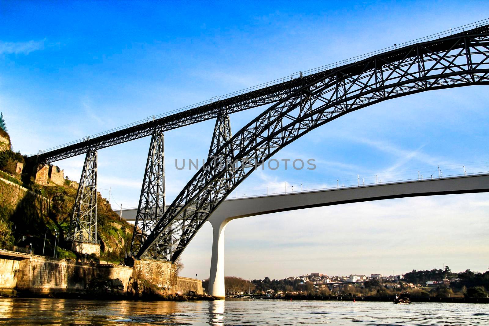 Beautiful and colossal iron bridge called Dom Luis I over the waters of the Douro River in Porto