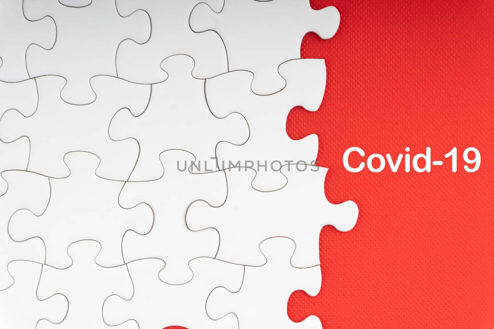 COVID-19 text with jigsaw puzzle on red background. Covid-19 and Coronavirus Concept