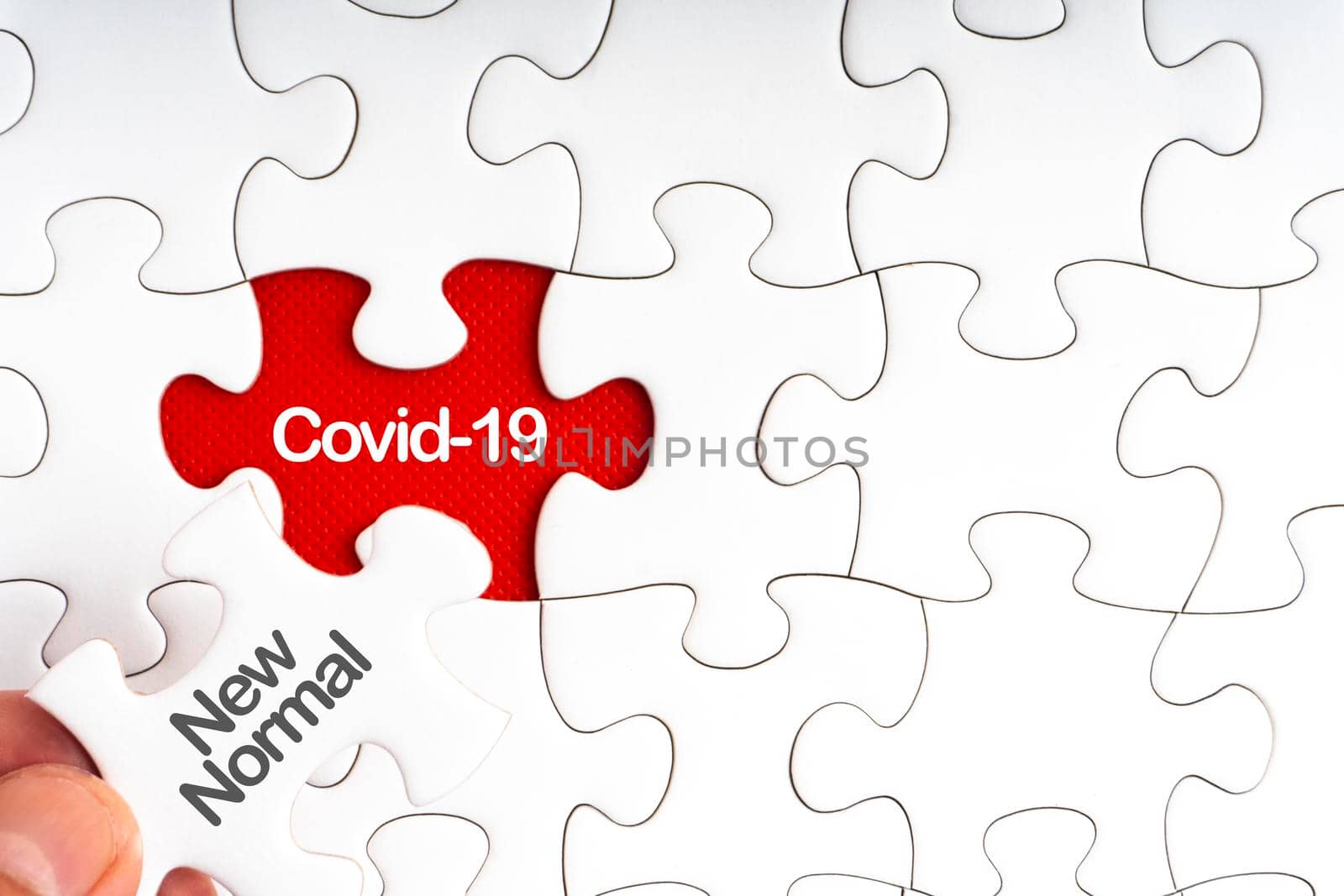 COVID-19 NEW NORMAL text with jigsaw puzzle on red background. by silverwings