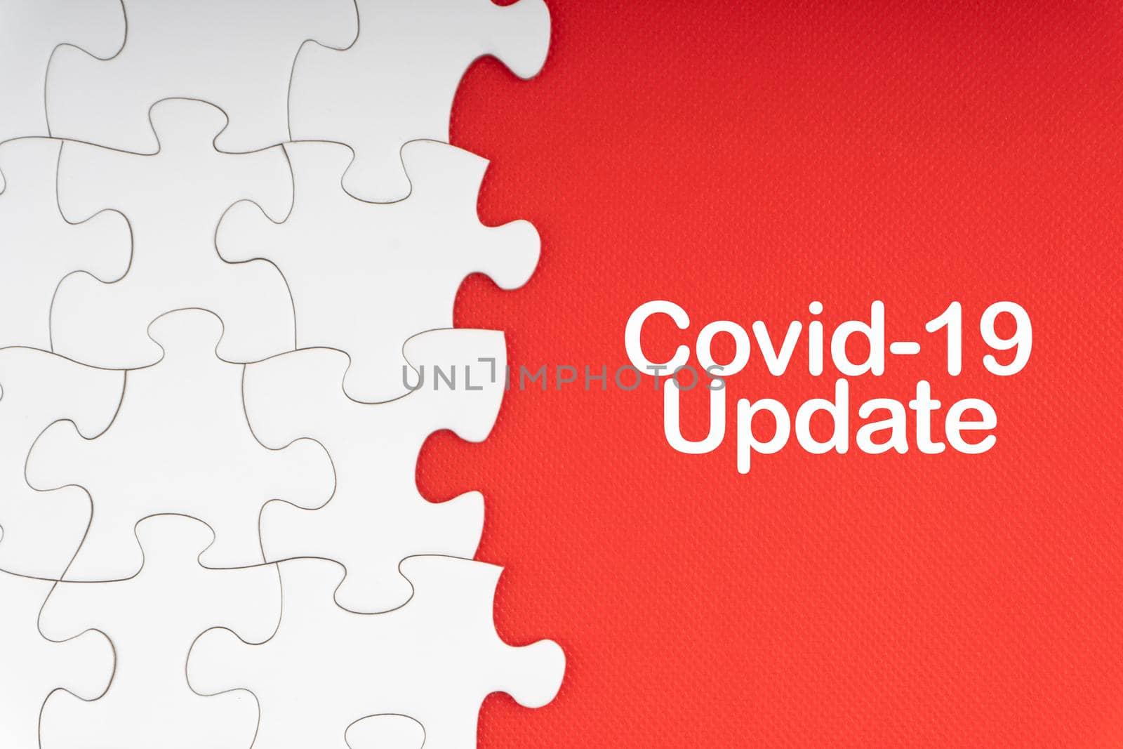 COVID-19 UPDATE text with jigsaw puzzle on red background. by silverwings