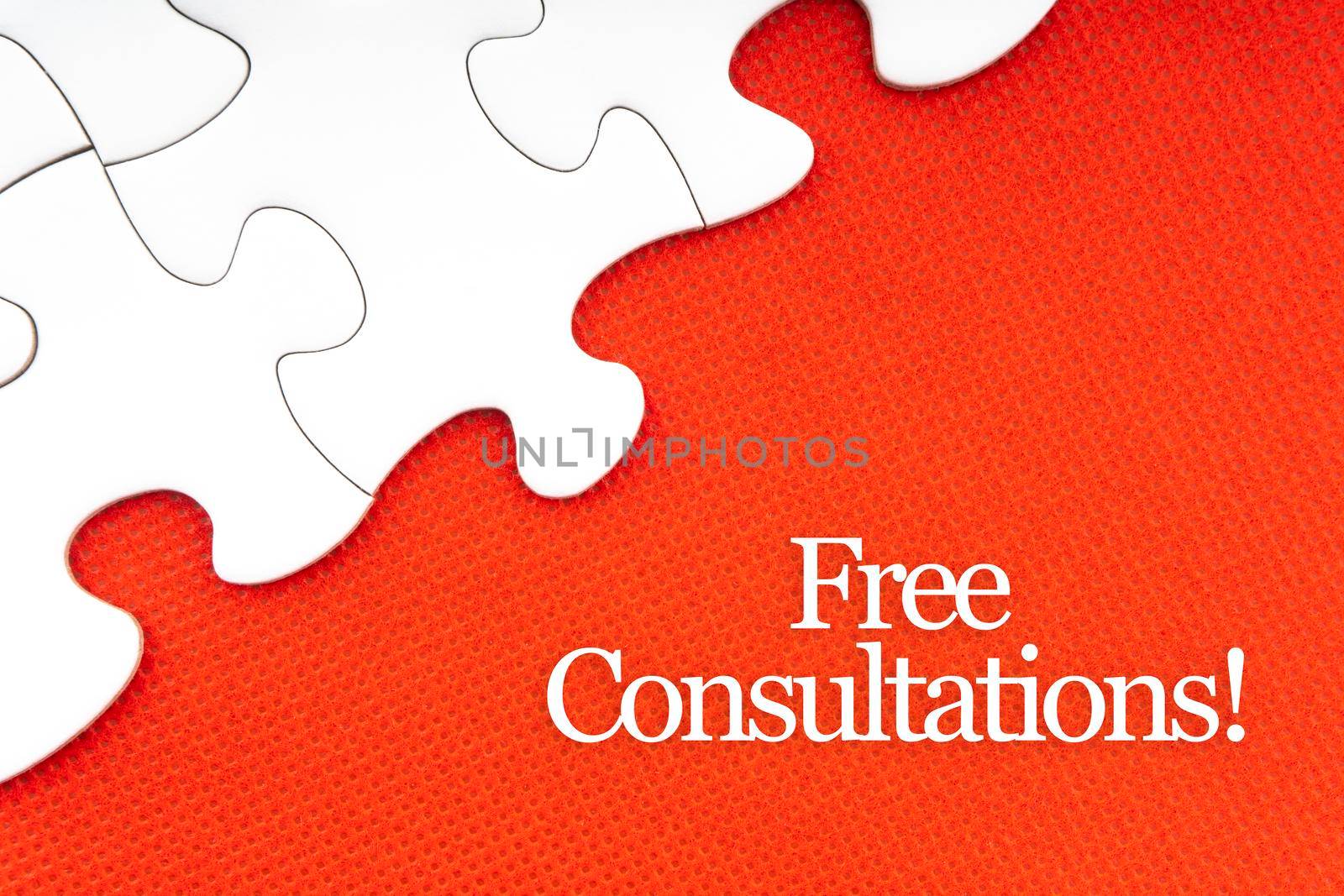 FREE CONSULTATIONS text with jigsaw puzzle on red background. Business and Motivation Concept