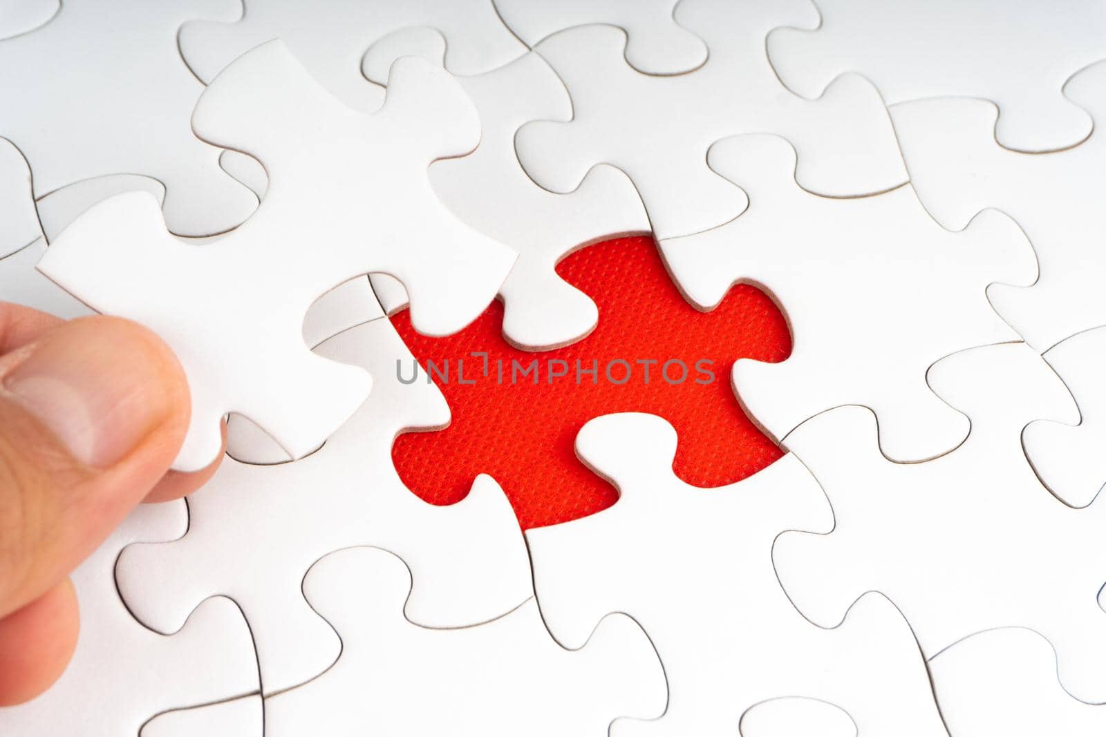 Hands holding Red jigsaw puzzle pieces on red background.nd.  by silverwings